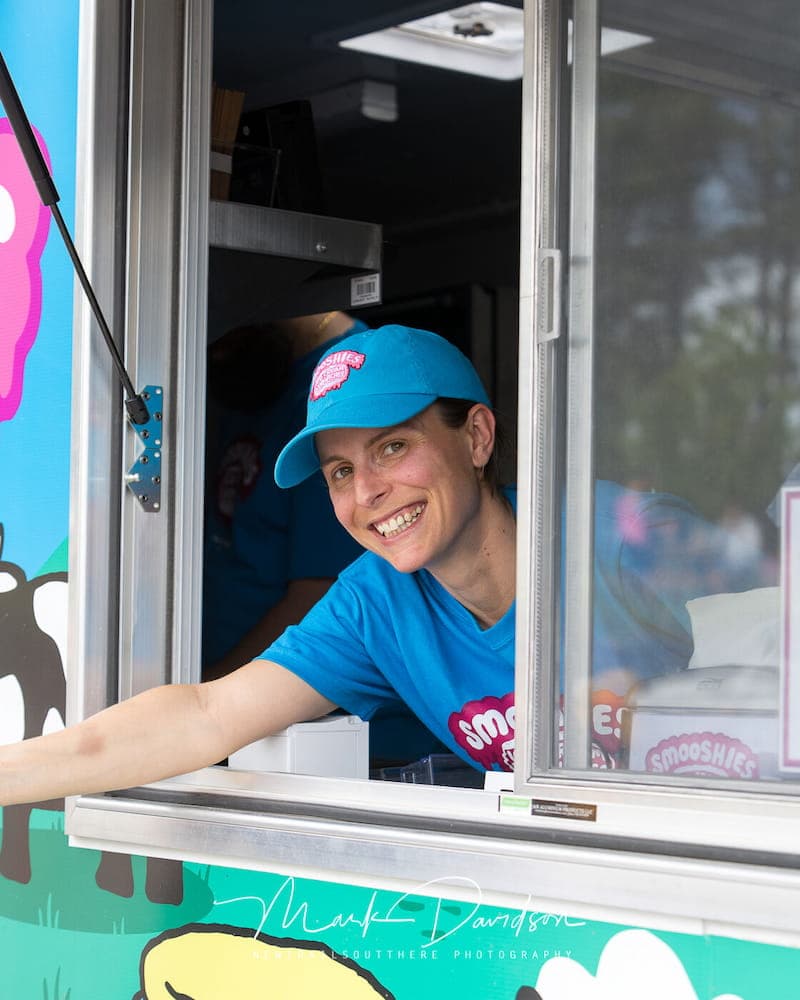Smooshies food truck server smiling while handing out an ice cream sandwich.