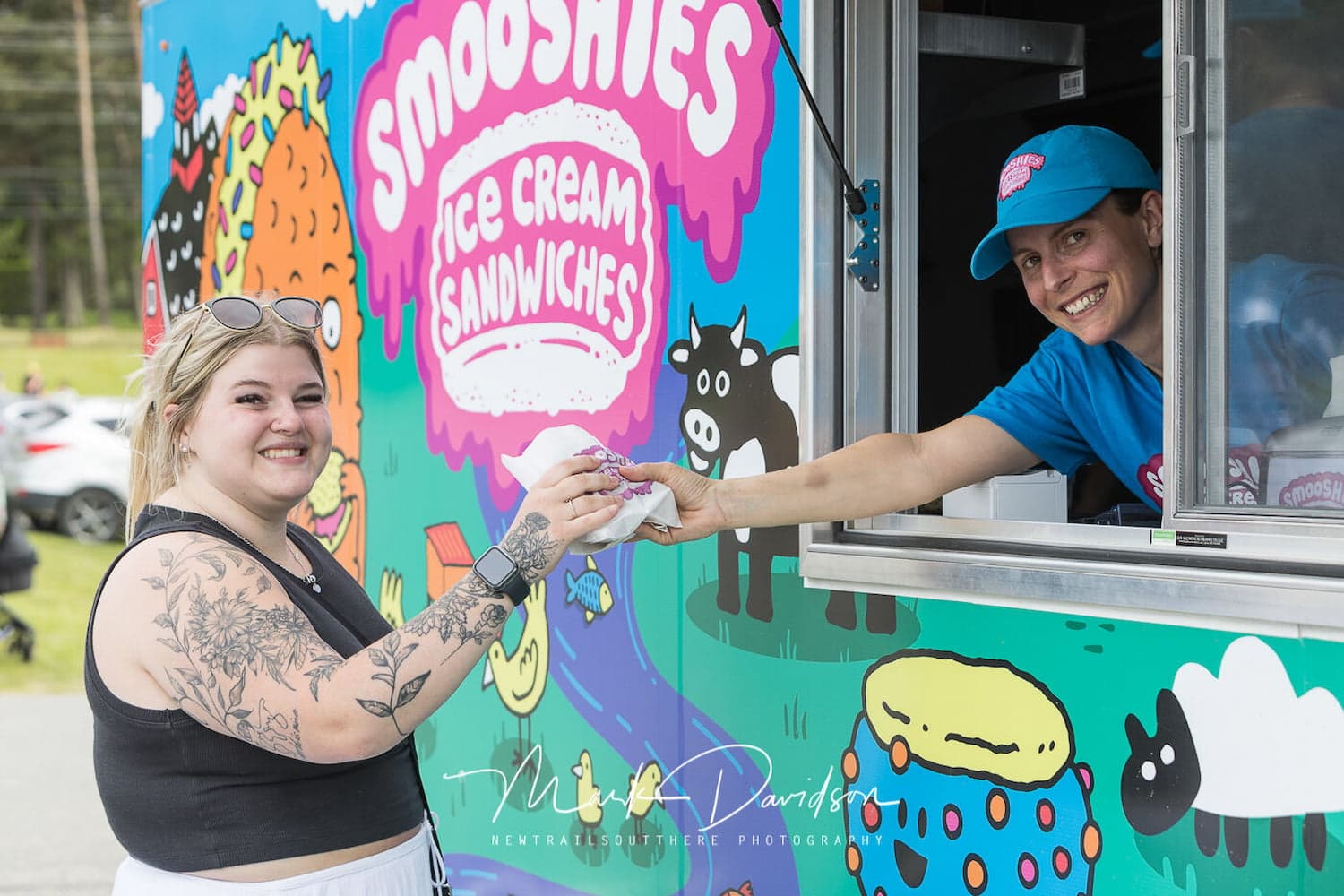 Customer being served an ice cream sandwich from the Smooshies food truck at a food truck rally.