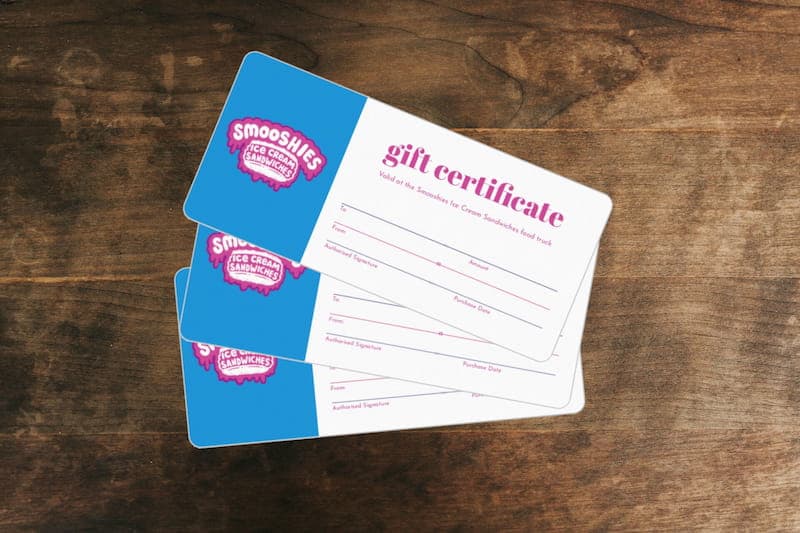 Smooshies gift certificates spread over a wood table.