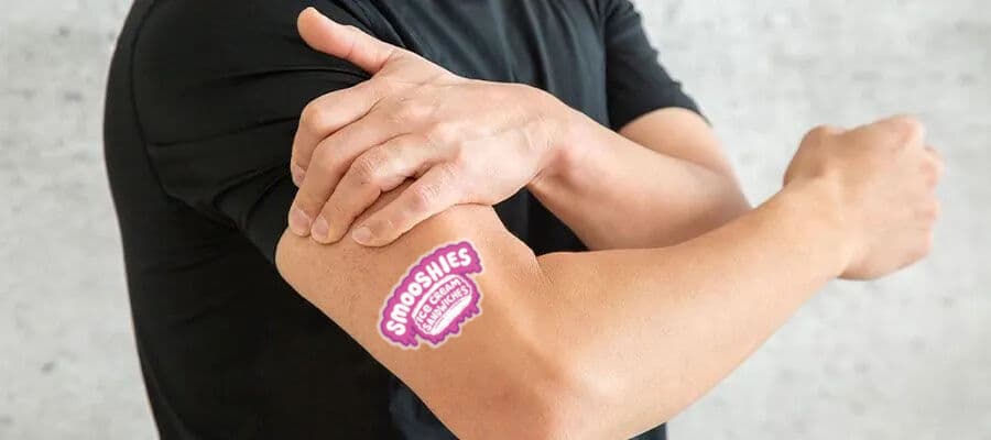 Smooshies logo tattoo displayed on a bicep.